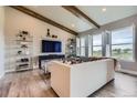 Cozy living room with vaulted ceilings, wood beams, large windows, and stylish decor at 6805 Zebra Grass Ln, Parker, CO 80138