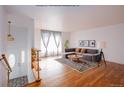 Living room with hardwood floors, staged furniture, and large window at 1536 S Wright Ct, Lakewood, CO 80228