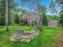 Backyard retreat with mature trees, a firepit sitting area, and a separate garage in a serene setting at 2654 Sinton Rd, Evergreen, CO 80439