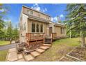 Charming home with tiered deck, landscaped yard and natural light, nestled in a wooded setting against a blue sky at 2654 Sinton Rd, Evergreen, CO 80439