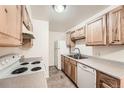 Functional kitchen featuring light wood cabinets, neutral countertops and white appliances at 16259 W 10Th Ave # K1, Golden, CO 80401