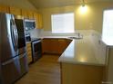 Bright kitchen featuring stainless steel appliances, wood cabinets, and light countertops at 3271 E 103Rd Pl # 1307, Thornton, CO 80229
