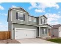 Two-story house with gray siding, white garage door, and landscaping at 2215 Alyssa St, Fort Lupton, CO 80621