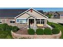 Inviting home featuring a front porch with seating, stone accents, and a well-manicured yard at 12604 Madison Way, Thornton, CO 80241