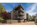 Contemporary condo building featuring multiple balconies and a landscaped exterior at 675 S University Blvd # 106, Denver, CO 80209