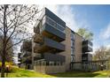 Multi-story building featuring balconies, well-kept lawns, and mature trees at 675 S University Blvd # 106, Denver, CO 80209