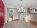 Elegant dining room featuring hardwood floors, modern chandelier, and staircase at 11545 S Flower Mound Way, Parker, CO 80134