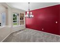 Inviting dining room with large window, stylish chandelier, and accent wall at 11545 S Flower Mound Way, Parker, CO 80134