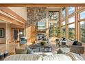 Cozy living room featuring a stone fireplace, hardwood floors, and expansive windows at 91 Hess Ave, Golden, CO 80401