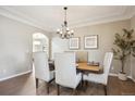 Formal dining room featuring crown molding, hardwood floors, and a stylish chandelier at 3970 White Bay Dr, Highlands Ranch, CO 80126