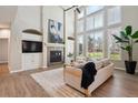 Bright living room with soaring ceilings, large windows, fireplace, and custom built-ins at 3970 White Bay Dr, Highlands Ranch, CO 80126