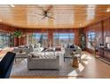 A wood paneled living room with bright windows features comfortable seating and scenic mountain views at 8258 W 66Th Dr, Arvada, CO 80004