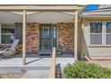 Close-up of the front entrance with a brick facade and covered porch at 9925 W Progress Pl, Littleton, CO 80123