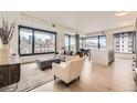 Bright living room with hardwood floors, floor-to-ceiling windows and city views at 1750 Wewatta St # 704, Denver, CO 80202