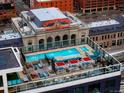Stunning aerial view of a rooftop pool and lounge area overlooking the iconic Union Station and the surrounding city at 1750 Wewatta St # 704, Denver, CO 80202