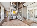 Grand entryway with staircase, hardwood floors, a charming rug and elegant console table at 10151 E 138Th Pl, Brighton, CO 80602