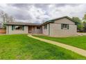 Inviting single-story home featuring a walkway leading to the front entrance and lush green lawn at 3000 Alkire St, Golden, CO 80401