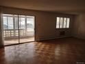 Living room showcasing hardwood floors, natural light, and sliding glass door to a sunroom at 680 S Alton Way # 9A, Denver, CO 80247