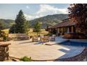 Backyard patio features a pool, spa, fire pit, outdoor seating and scenic mountain views at 6455 Dakota Ridge Dr, Golden, CO 80403