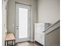 Bright entryway with a frosted glass door, hardwood floors, storage cabinet and bench at 2521 Moline St, Aurora, CO 80010