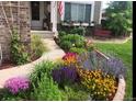 Beautifully landscaped front yard with vibrant flowers and a well-maintained walkway at 6502 Shea Pl, Highlands Ranch, CO 80130