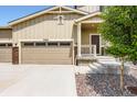 Charming tan two story home with a 3-car garage, well maintained lawn, and stone accents at 42830 Ivydel St, Elizabeth, CO 80107