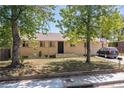 Charming single-story home with brick facade, complemented by mature trees and a well-maintained front yard at 140 S Kendall St, Lakewood, CO 80226