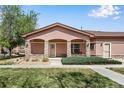 Charming home exterior with manicured lawn, stone pillars and covered front porch at 15501 E 112Th Ave # 33D, Commerce City, CO 80022