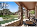 Inviting covered patio with stone columns, offering a peaceful outdoor space with views of the landscaped community at 15501 E 112Th Ave # 33D, Commerce City, CO 80022
