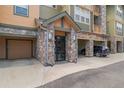Apartment entrance with stone accents, covered parking and a walkway to the front door at 15460 Canyon Gulch Ln # 105, Englewood, CO 80112