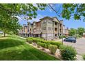 Apartment building with well-kept lawns, attractive landscaping, and a side view of the parking area at 15460 Canyon Gulch Ln # 105, Englewood, CO 80112