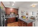 Well-equipped kitchen with dark wood cabinets, granite countertops, and stainless steel appliances at 15460 Canyon Gulch Ln # 105, Englewood, CO 80112