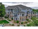 Blue townhome exterior with stone accents, well-kept landscaping, and inviting balconies at 5255 Memphis St # 1009, Denver, CO 80239