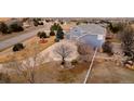 Scenic aerial view of the home with a circular driveway, mature trees, and white fence at 9407 E 147Th Pl, Brighton, CO 80602