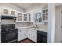 Cozy kitchen featuring tile countertops, white cabinets, and black appliances at 1947 S Ouray St, Aurora, CO 80013