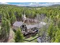 A lovely home nestled in the trees with a deck and grassy backyard at 24 Navajo Trl, Evergreen, CO 80439
