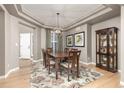 Formal dining room featuring a beautiful chandelier, artwork, and hardwood floors with decorative rug at 6690 S Fenton St, Littleton, CO 80123