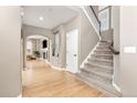 Spacious entryway featuring hardwood floors, staircase, and an open view to the living room with fireplace at 6690 S Fenton St, Littleton, CO 80123