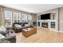 Cozy living room with a fireplace, a large window, hardwood floors, and comfortable leather seating at 6690 S Fenton St, Littleton, CO 80123