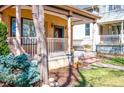 Inviting covered porch with classic columns, decorative flowerpots, and a well-manicured lawn at 433 N Ogden St, Denver, CO 80218