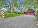 Charming home with a spacious driveway, lush lawn, mature trees, and a two-car garage at 845 Urban St, Lakewood, CO 80401