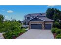 Charming two-story home featuring a stone facade, three-car garage, covered porch and meticulously maintained lawn at 14620 Prairie Sky Ln, Broomfield, CO 80023