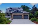 Beautiful two-story home featuring a stone facade and a three-car garage, with attractive landscaping at 14620 Prairie Sky Ln, Broomfield, CO 80023