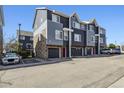 Townhome exterior showcasing the garage, stone accents and street view at 8751 Pearl St # J3, Thornton, CO 80229