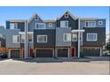 View of the townhome with brick facade, gray siding and red door at 8751 Pearl St # J3, Thornton, CO 80229