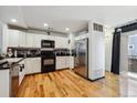 Bright kitchen with white cabinets, stainless steel appliances, and hardwood floors, offering a clean and modern space at 8751 Pearl St # J3, Thornton, CO 80229