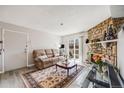 Inviting living room with a stone fireplace, plush sofa, and sliding doors to a balcony at 4400 S Quebec St # 107, Denver, CO 80237