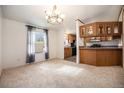 Cozy dining area with large window and adjacent kitchen featuring wood cabinets at 1683 Monroe St, Strasburg, CO 80136
