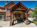 Grand front entrance with a covered porch, brick pillars, and a stone pathway at 5 Walden Ln, Cherry Hills Village, CO 80121