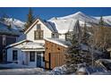 Charming home with snow-covered roof, wood siding, and mountain views at 208 N Ridge St, Breckenridge, CO 80424